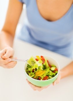 healthy food and kitchen concept - woman eating salad with vegetables