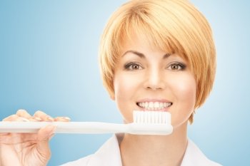 health, medicine, hospital concept - attractive female doctor with toothbrush