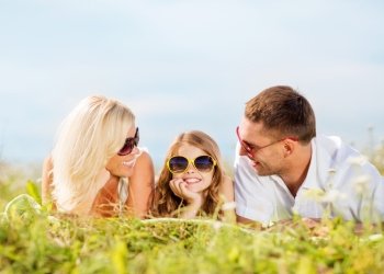 summer holidays, children and people concept - happy family with blue sky and green grass