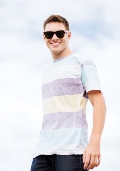 summer holidays and teenage concept - man in shades outside