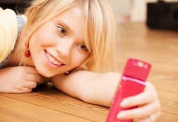 technology concept - teenage girl making self portrait with smartphone