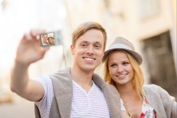 summer holidays, travel, vacation, tourism and dating concept - travelling couple taking photo picture with camera
