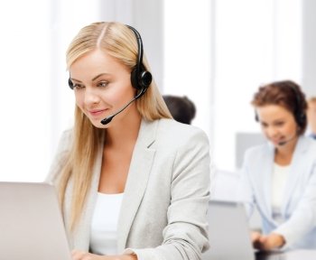 business, call centre and technology concept - female helpline operator with headphones and laptop pc