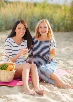 summer holidays and vacation concept - girls with drinks on the beach