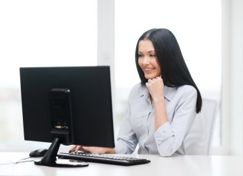 office, business, education, technology and internet concept - smiling businesswoman or student with computer