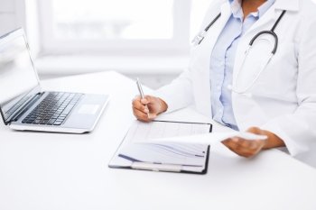 healthcare and medical concept - female doctor writing prescription