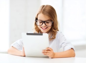 education, school, technology and internet concept - little student girl in black eyeglasses with tablet pc computer at school