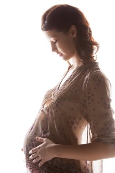 family, motherhood and pregnancy concept - silhouette backlight picture of pregnant beautiful woman