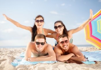 summer, holidays, vacation and happy people concept - group of smiling people in sunglasses having fun on the beach