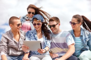 summer holidays, teenage and technology concept - group of smiling teenagers in sunglasses looking at tablet pc