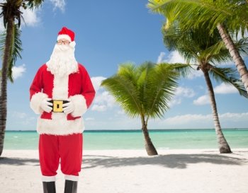 christmas, holidays and people concept - man in costume of santa claus over tropical beach background