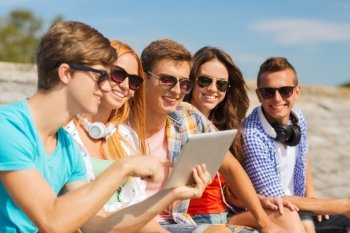 friendship, leisure, summer and people concept - group of smiling friends with tablet pc computer sitting outdoors