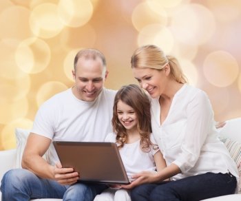 family, childhood, holidays, technology and people concept - smiling family with laptop computer over beige lights background