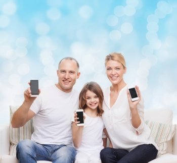 holidays, technology, advertisement and people concept - smiling family with smartphones over blue lights background