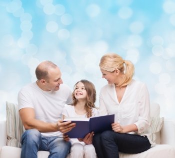family, childhood, holidays and people - smiling mother, father and little girl reading book over blue lights background