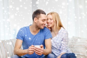 love, family, drinks and people concept - smiling couple with cup of tea or coffee at home