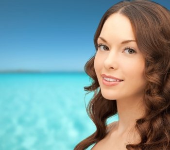 people and beauty concept - beautiful young woman over blue sky and sea background