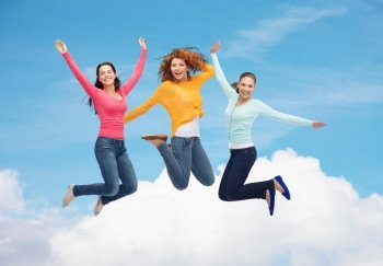 happiness, freedom, friendship, movement and people concept - group of smiling young women jumping in air over blue sky with white cloud background