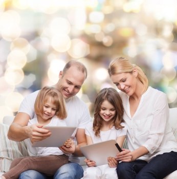 family, holidays, technology and people - smiling mother, father and little girls with tablet pc computers over lights background
