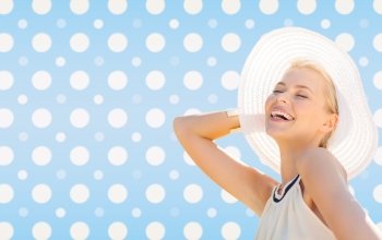 fashion, happiness and people concept - beautiful smiling woman in white summer hat over blue and white polka dots pattern background