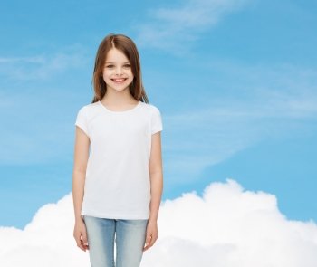 advertising, dream, childhood and people - smiling little girl in white blank t-shirt over blue sky background