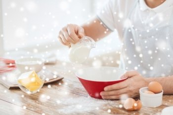 cooking, food, people and home concept - close up of man pouring milk to bowl