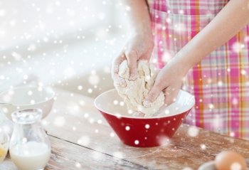cooking, baking, food, people and home concept - close up of female hands kneading dough in kitchen