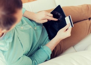 technology, shopping, banking, leisure and lifestyle concept - close up of man with laptop computer and credit card at home