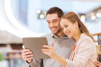 shopping, technology and people concept - happy couple with tablet pc taking selfie in mall or business center