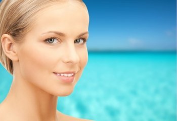 beauty, people and health concept - beautiful young woman face over blue sky and sea background