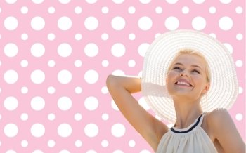 fashion, happiness and people concept - beautiful smiling woman in white summer hat over pink and white polka dots pattern background