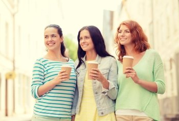 vacation, weekend, drinks and friendship concept - smiling teenage girls with coffee cups on street