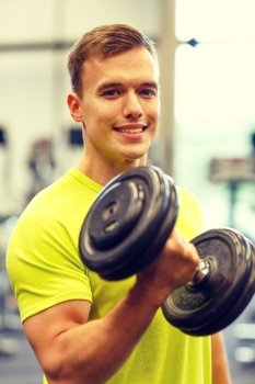 sport, fitness, lifestyle and people concept - smiling man with dumbbell in gym