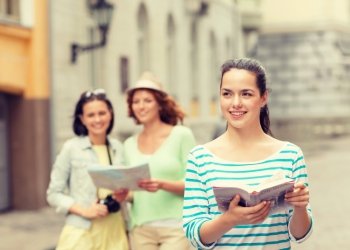 tourism, travel, leisure and holidays concept - smiling teenage girls with city guide, map and camera outdoors