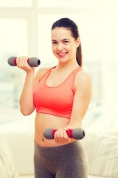 fitness, home and diet concept - smiling redhead girl exercising with heavy dumbbells at home