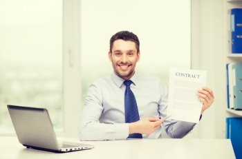 business, office and technology concept - smiling businessman with laptop computer and contract at office