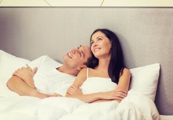 hotel, travel, relationships, and happiness concept - happy couple dreaming in bed