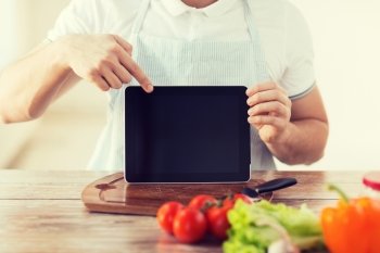 cooking, technology, advertising and home concept - close up of male hands holding tablet pc with blank black screen and pointing to it