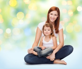 childhood, motherhood, parenting and relationship concept - happy mother with adorable little girl over green lights background