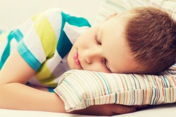 health, sleeping and dreaming concept - little boy sleeping at home
