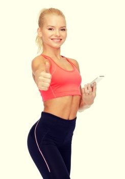 sport, fitness, technology, internet and healthcare - smiling sporty woman with smartphone showing thumbs up