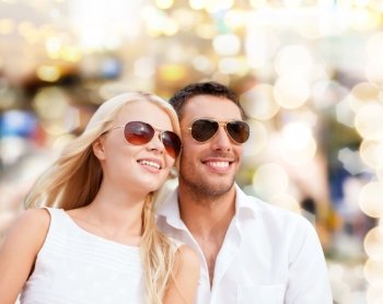 summer holidays, people and dating concept - happy couple in shades over lights background