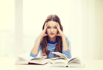 education and home concept - stressed student girl with books