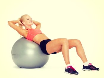 fitness, exercise and diet concept - smiling sporty woman exercising on fitness ball