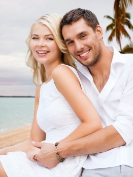 summer holiday, vacation, dating, travel and tourism concept - happy couple having fun and hugging over beach background