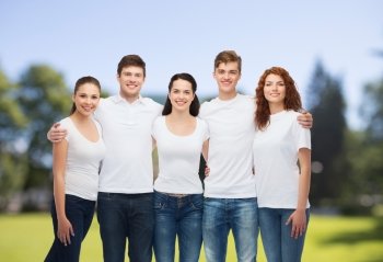 advertising, nature, summer holidays and people concept - group of smiling teenagers in white blank t-shirts