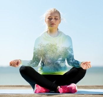 sport, fitness, yoga, double exposure and people concept - happy young woman meditating in lotus pose over blue sky with sea and tree background