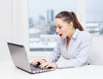 business and office concept - surprised businesswoman using her laptop computer