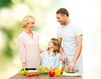 vegetarian food, culinary, happiness and people concept - happy family cooking vegetable salad for dinner and talking over green natural background