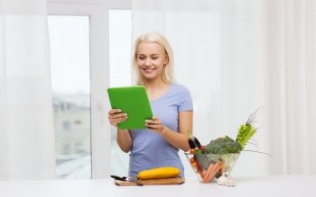 healthy eating, cooking, vegetarian food, technology and people concept - smiling young woman with tablet pc computer and bowl of vegetables at home